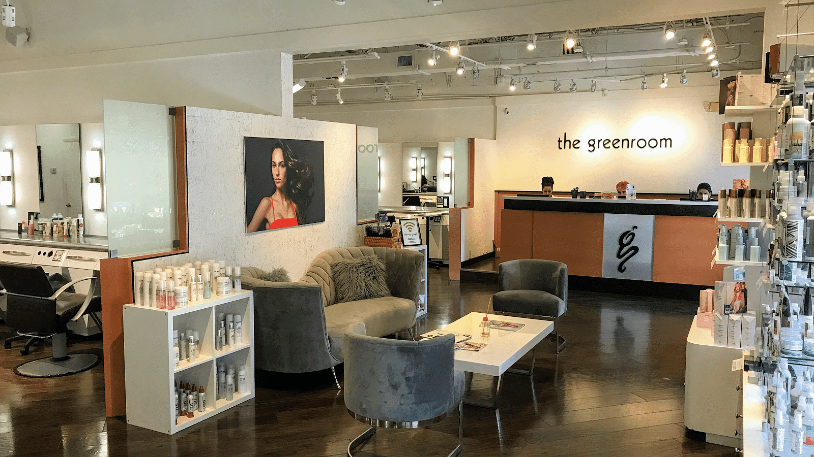 Cozy salon interior with seating, hair products, and reception desk.